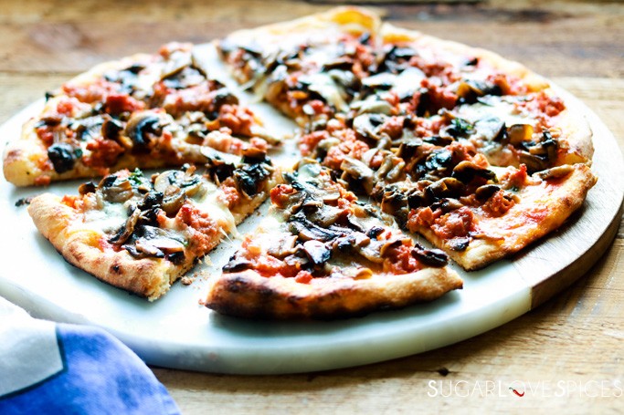 pizza funghi e salsiccia-slices cut on a marble board